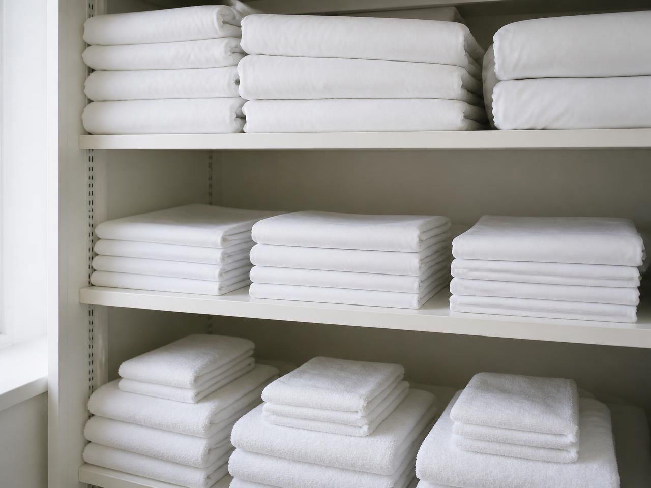 Linge hôtelier professionnel plié : draps, housses de couette et serviettes